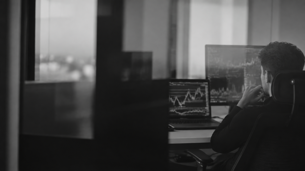 Trader reviewing financial markets through a reflective office partition